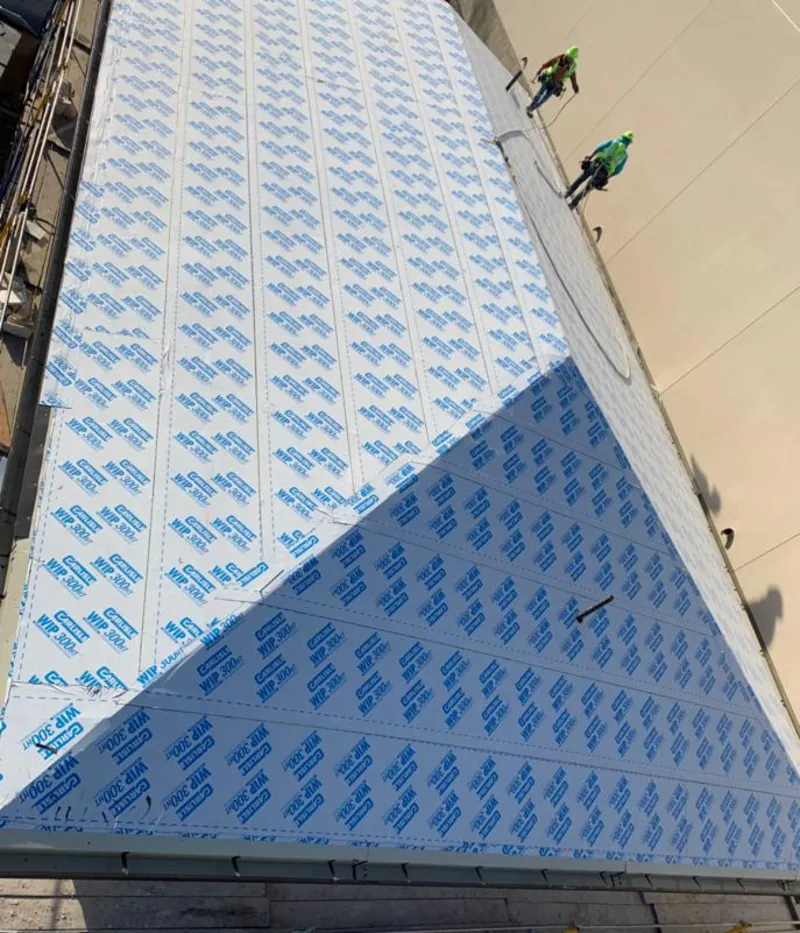 Professional roofers installing underlayment on a metal roof in State College